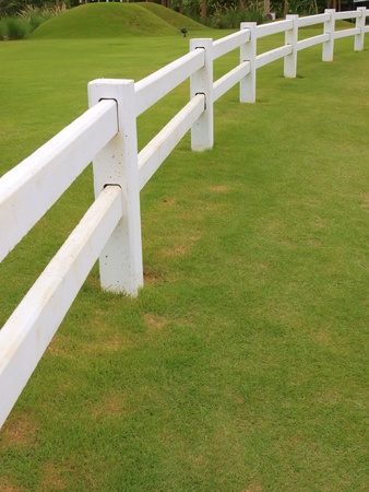 white fence on green fieldの写真素材