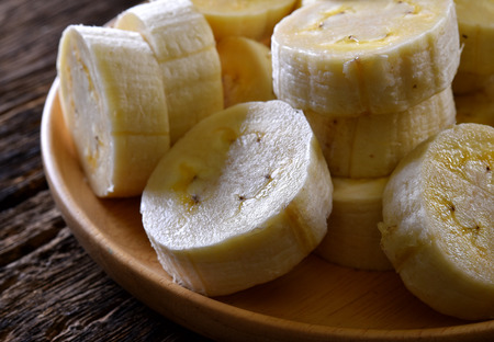 Banana in wooden dish on woodの写真素材