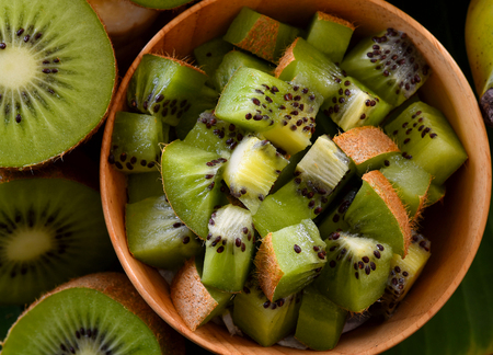 Kiwi in a wooden bowlの写真素材