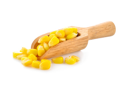 sweet corn seeds in wood scoop on white backgroundの写真素材