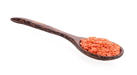 Red lentils in wood spoon on white backgroundの写真素材