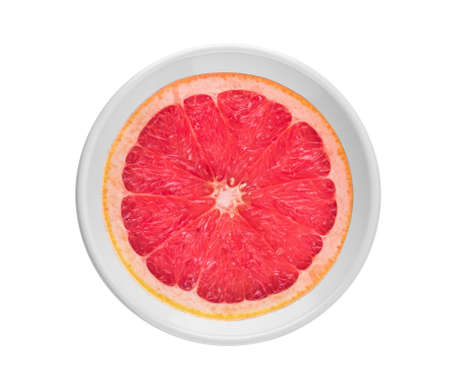 Orange slice in white plate on white backgroundの写真素材