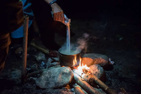 Cooking in field conditions, boiling pot at the campfire on picnicの写真素材