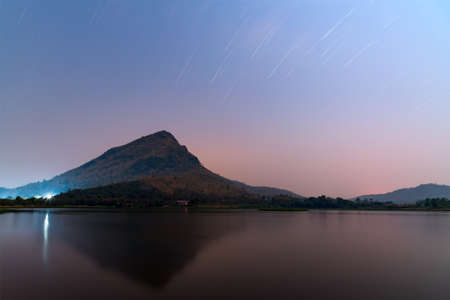 Long exposure image of mountain reflex on the lake under star and moonlight night.の写真素材