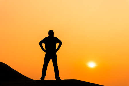 Silhouette of woman is standing and enjoy sunrise view.の写真素材