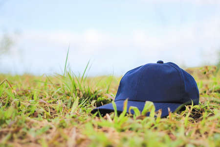 Blue cap put on grass field.の写真素材