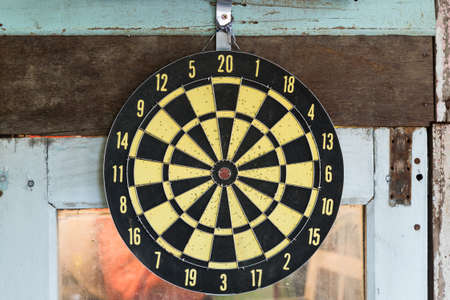 Yellow classic darts board on the old window.の写真素材