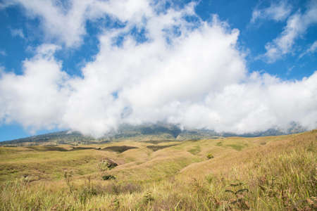 Mountain and savannah field with cloud and blue sky. Rinjani mountain, Lombok island, Indonesia.の写真素材