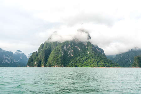 Mountain was covered by fog inside the lake. Cheow Lan Dam. Khao Sok National Park. Thailand.
