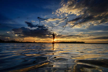 Fisherman of Huitong Lake in action when fishing, Thailandの写真素材