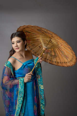 Beautiful Asian model Young asia Oriental woman wearing chinese qipao dress - studio shotの写真素材