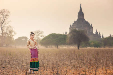 Beautiful girl in Myanmar traditional costume,  identity culture of Myanmar, Pagdodas of Bagan Background, Happy asian womanの写真素材
