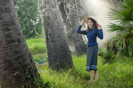 Thai Farmer woman wearing typical Thai dress, on Rice fields background, identity culture of Thailandの写真素材