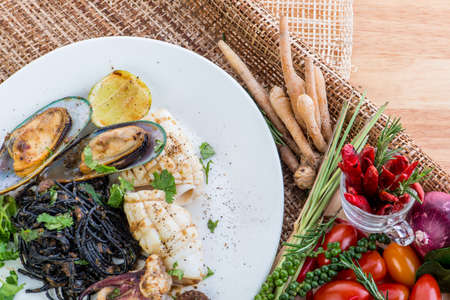 Black spaghetti Alle Vongole. Black seafood pasta with clams and yogurt garlic sauce over black table. Mediterranean delicacy,seafood black pasta with shrimp, octopus and parsleyの写真素材