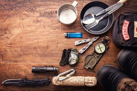 Outdoor travel equipment planning for a mountain trekking camping trip on wooden background. Top view - vintage film grain filter effect stylesの写真素材