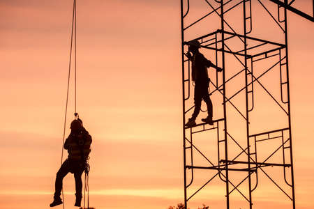 Silhouette Engineers Worker discussion with architects work planing in construction site working on high ground heavy industry and safety concept の写真素材