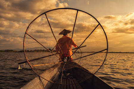 Intha Burmese fishermen on boat catching fish traditional at Inle Lake, Shan State, Myanmarの写真素材