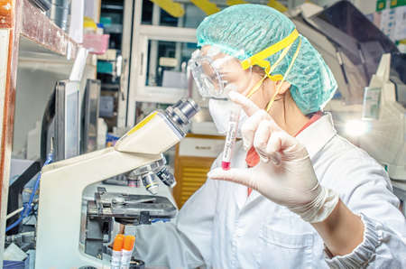 Coronavirus covid 19 epidemic disease with doctor or lab technician scientist holding blood sample...