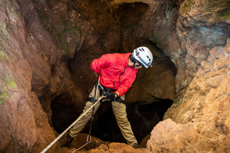 Rescuers or climber descends in a cave fast rope in the dark cavesの写真素材