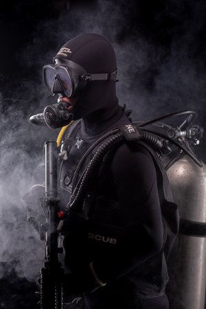 Spec ops police officer SWAT special forces  with a weapon in his hands. on a dark background. Law and order protection concept.  Poster concept for police, security or militaryの写真素材