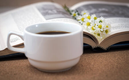 A cup of coffee and flower on a book の写真素材