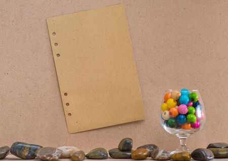 Paper stick on cork board with wooden beads in a glassの写真素材