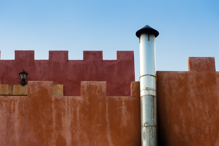Chimney with Orange Wall and Blue Skyの写真素材