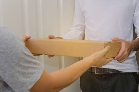 Close up of Man wiith wite clothes use two hands to receive packing of post delivery.
