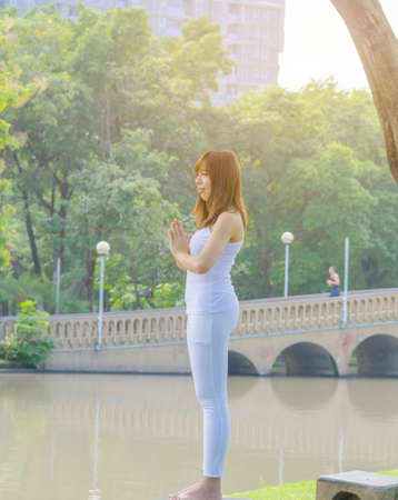 Beautiful girl practice yoga meditation at natural park,copy space.の写真素材