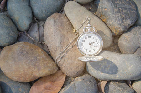Pocket watch on rock .