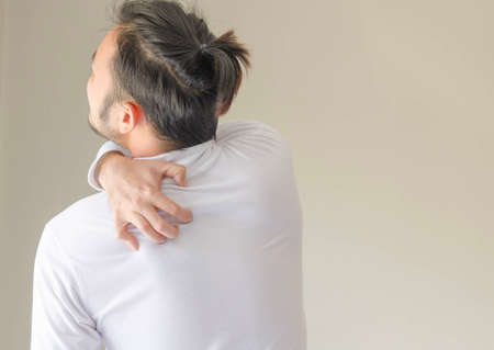 Man wearing white T-shirt suffer from sholder pain.の写真素材