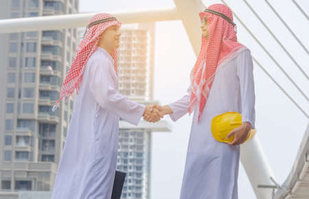 Arab businessman are shaking hand on cityscape background, successful concept.の写真素材