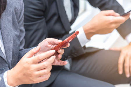 a couple of young business people sitting in the office and using smartphone, lifestyle and friendship concept,selective focus, copy space.の写真素材