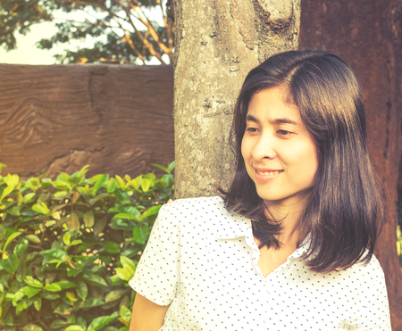 Portrait of a beautiful young asian girl relaxing in parkの写真素材