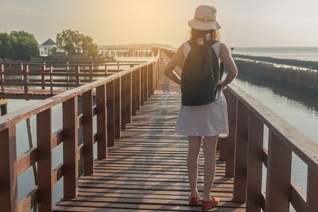 Young travel woman standing on long wooden bridgeの写真素材