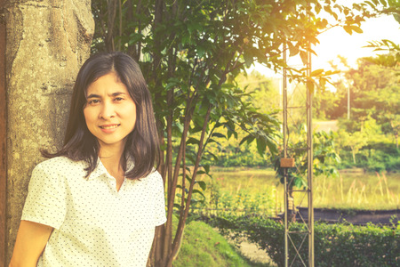 Portrait of a beautiful young asian girl relaxing in parkの写真素材