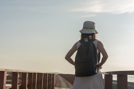 Young travel woman standing on long wooden bridgeの写真素材