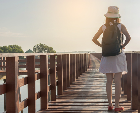 Young travel woman standing on long wooden bridgeの写真素材