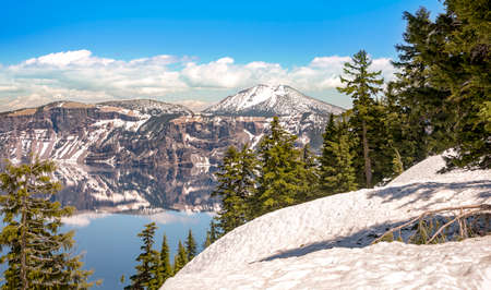 Crater Lake, with snow top mountain and clear blue lakeの写真素材