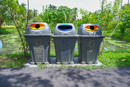Multi-colored garbage bins in the park, separate types, bins for general garbage. Garbage bin for glass bottles Garbage bin for cans and plastic bottlesの写真素材