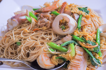 Hong Kong recipe stir-fried noodles with egg, fresh squid, pork, shrimp, pickled squid and Hong Kong vegetables.の写真素材