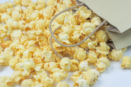 Lots of Butter Flavored Popcorn scattered on a white backgroundの写真素材