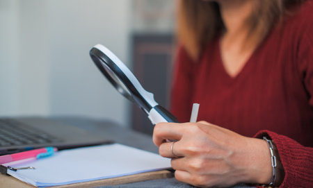 woman doing work and using a magnifying glass to look at data Suitable for making infographics.の写真素材