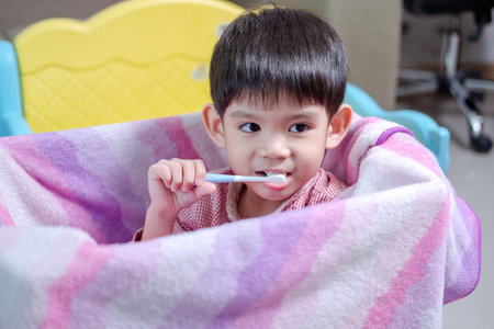 A boy brushes his teeth in his beloved toy box.