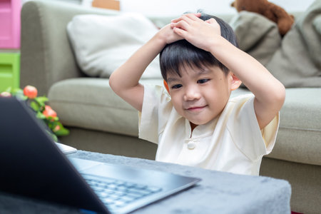 Asian boy studying online on laptop