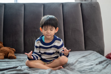 Asian boy doing meditation pose or yoga for kidsの写真素材