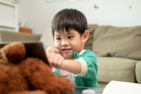 Asian boy studying online and doing activities on laptopの写真素材