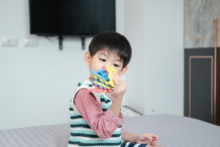 Asian boy playing with jigsaw puzzles on the bed joyfullyの写真素材