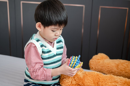 Asian boy playing with jigsaw puzzles on the bed joyfullyの写真素材