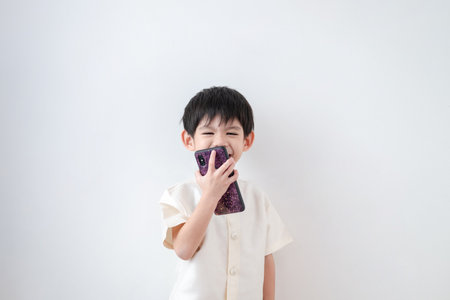 Asian boy Wear traditional Thai clothing Talk on the phone on a white backgroundの写真素材